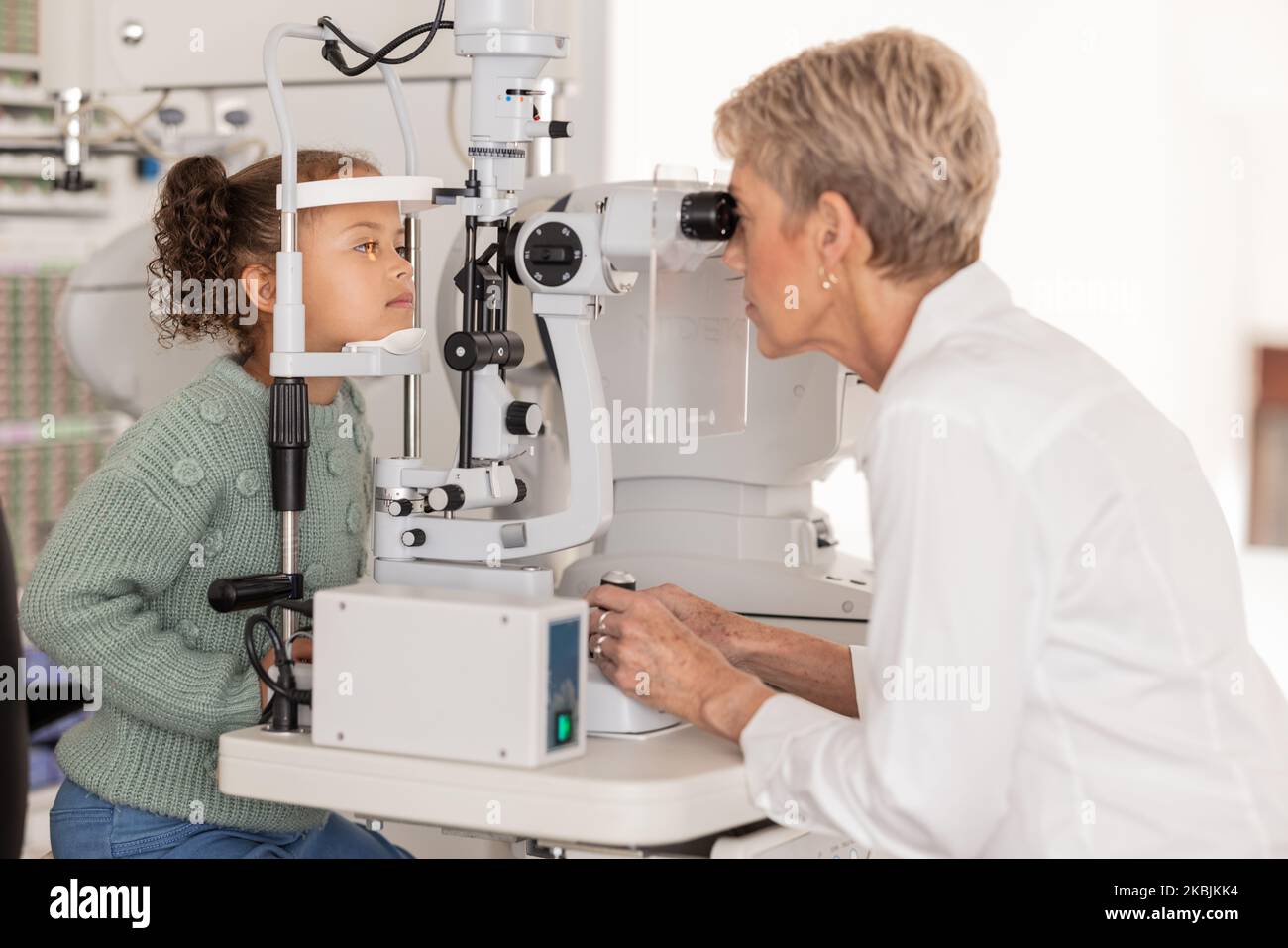Optometrist doing a vision test on girl at an optical, eyewear and