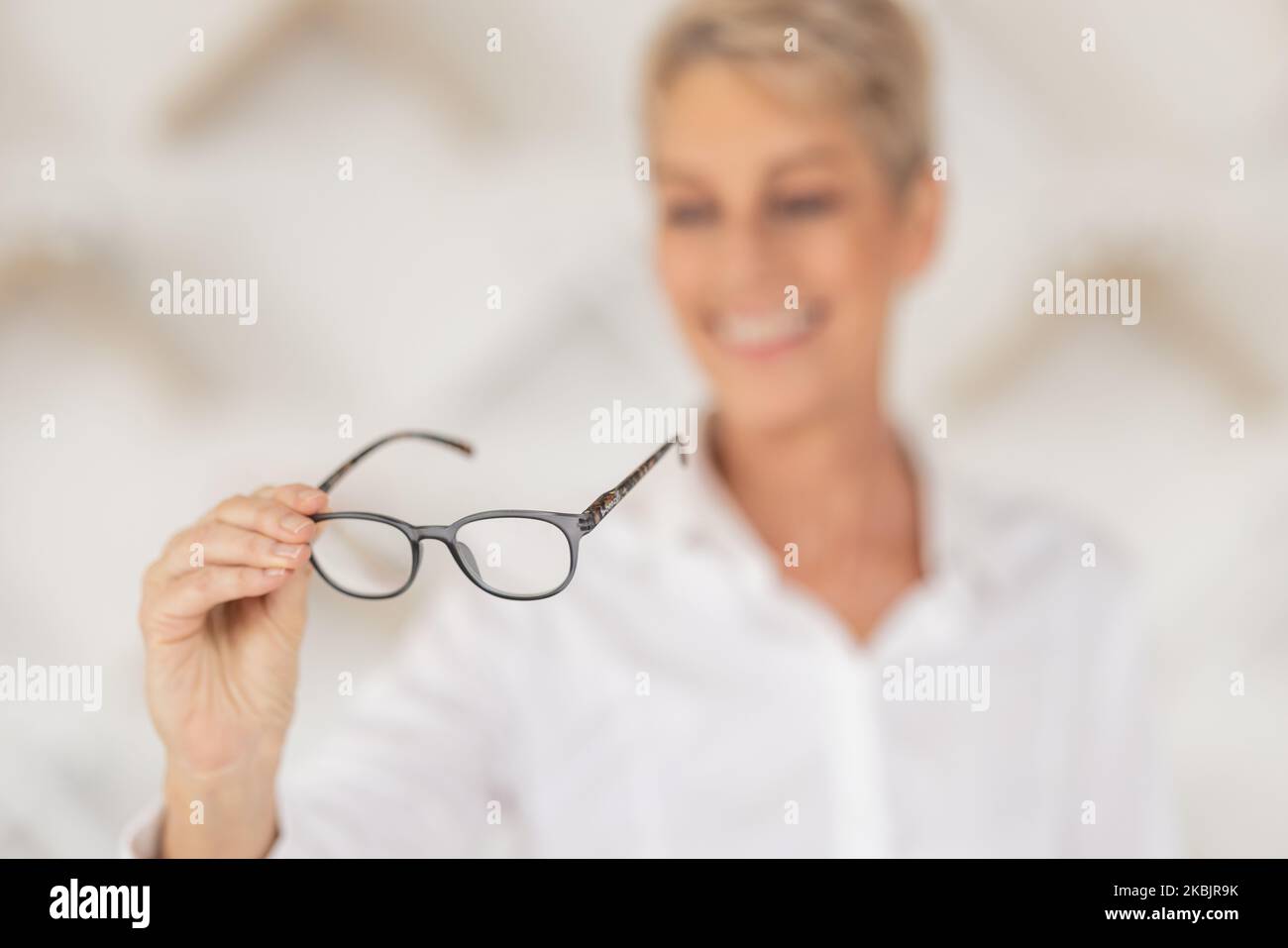 Vision, blur and woman holding glasses in an optometry store buying