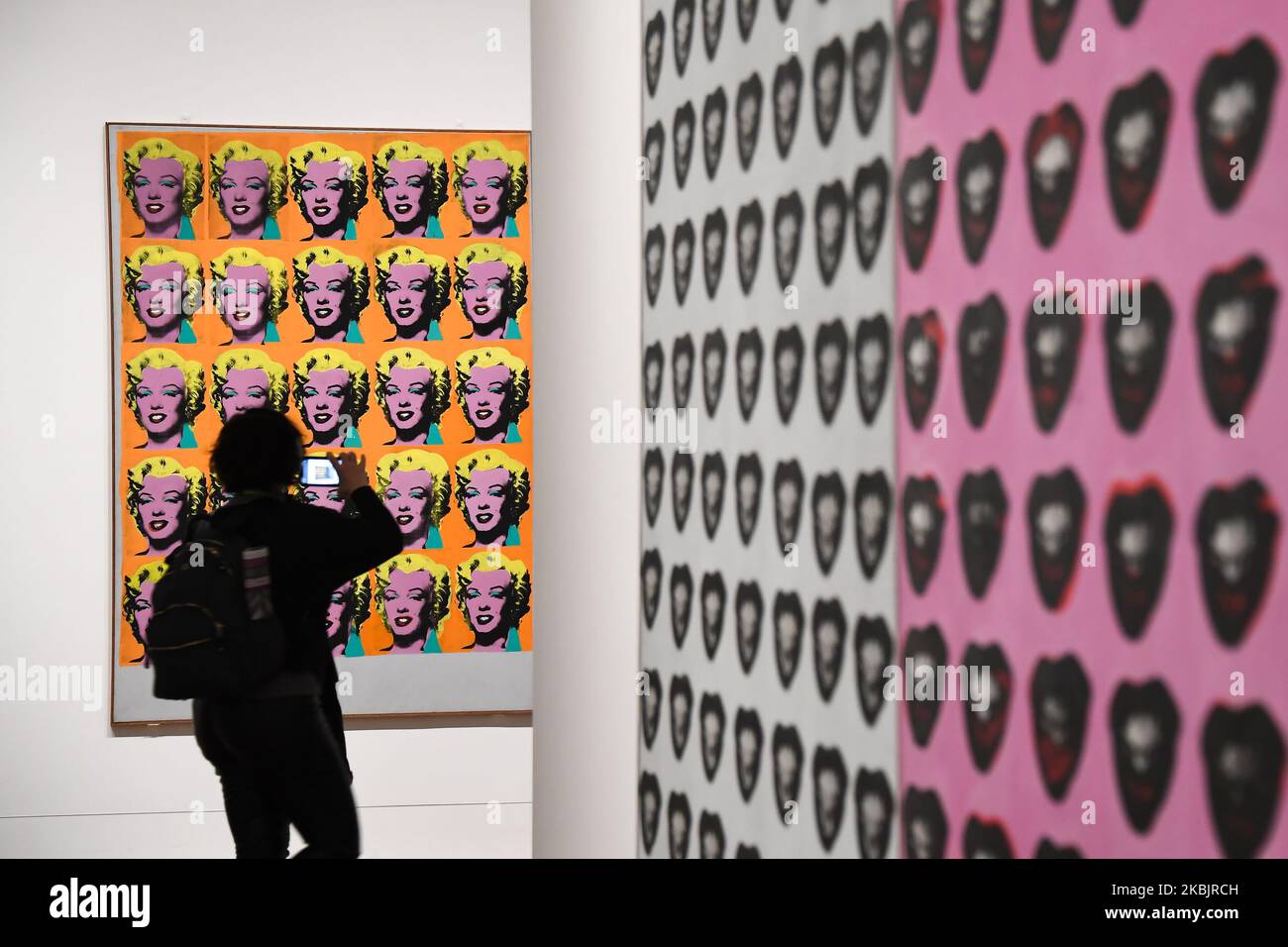 A gallery assistant poses with an artwork entitled "Marilyn Diptych" 1962," by US artist Andy Warhol during a press preview for the forthcoming Andy Warhol exhibition at the Tate Modern in London on March 10, 2020. - The exhibition is set to run from March 12 to September 6. (RESTRICTED TO EDITORIAL USE - MANDATORY MENTION OF THE ARTIST UPON PUBLICATION - TO ILLUSTRATE THE EVENT AS SPECIFIED IN THE CAPTION) (Photo by Alberto Pezzali/NurPhoto) Stock Photo