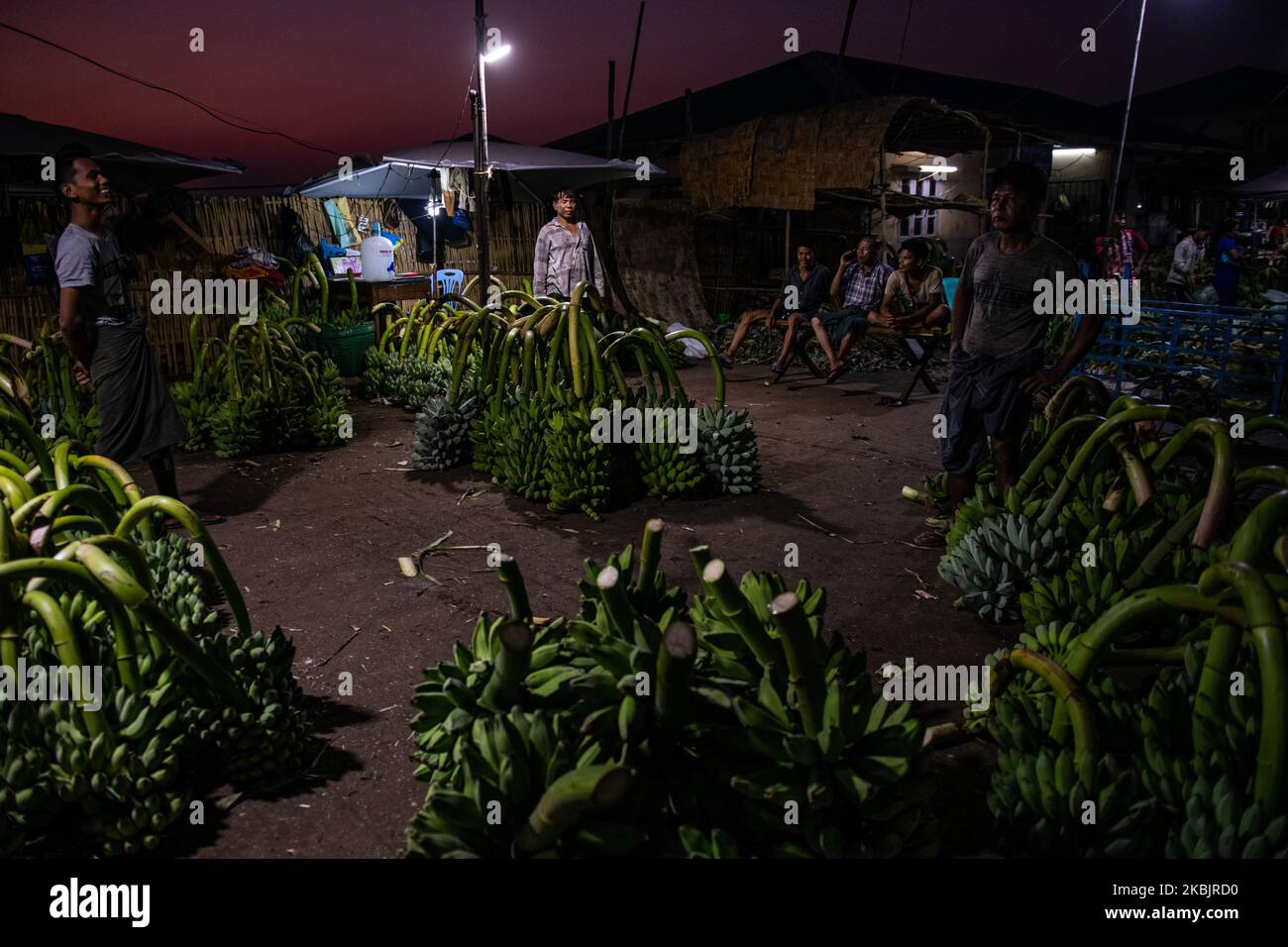 Workers during their break time near a pile of bananas at a wholesale market in Yangon, Myanmar on March 10, 2020. (Photo by Shwe Paw Mya Tin/NurPhoto) Stock Photo