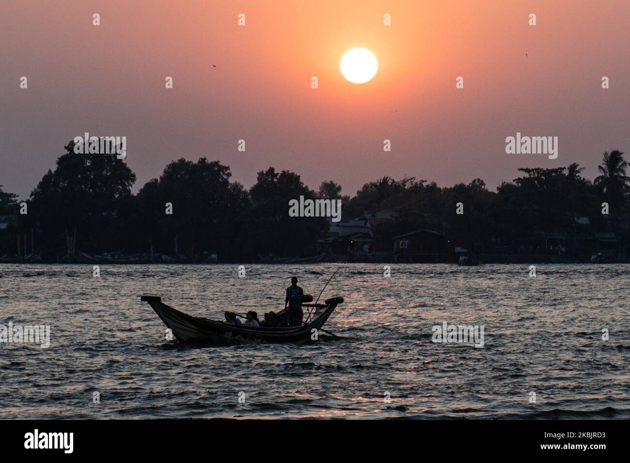 A boat crosses a river during the sunset in Yangon, Myanmar on March 10, 2020. (Photo by Shwe Paw Mya Tin/NurPhoto) Stock Photo