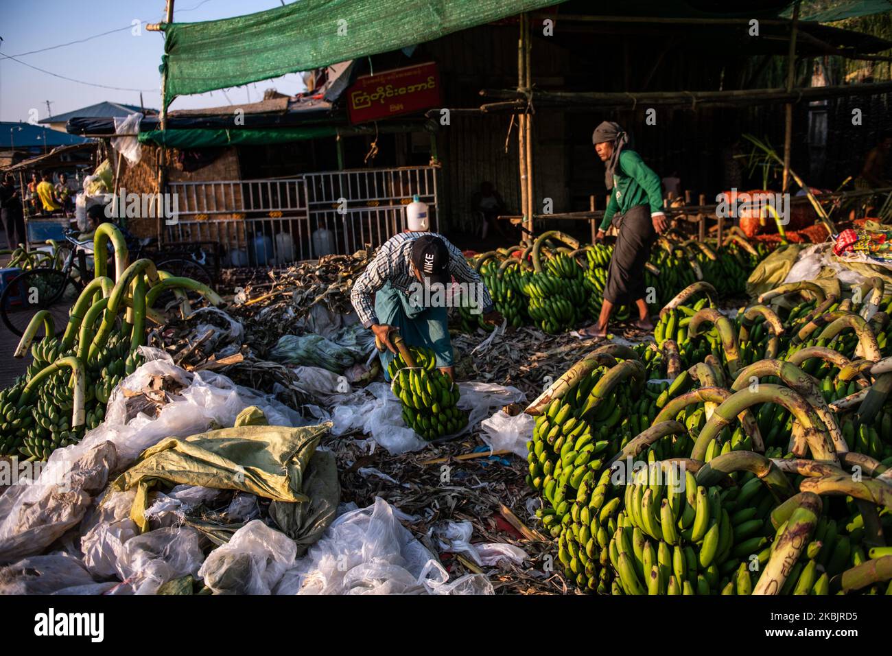 A man unpack bananas at a wholesale market in Yangon, Myanmar on March 10, 2020. (Photo by Shwe Paw Mya Tin/NurPhoto) Stock Photo