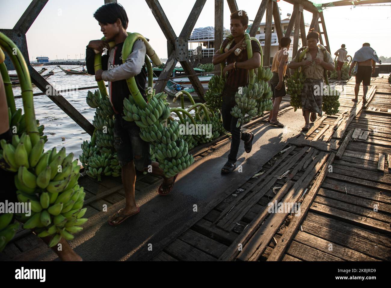People carry bananas unloaded from a boat at a jetty in Yangon, Myanmar on March 10, 2020. (Photo by Shwe Paw Mya Tin/NurPhoto) Stock Photo