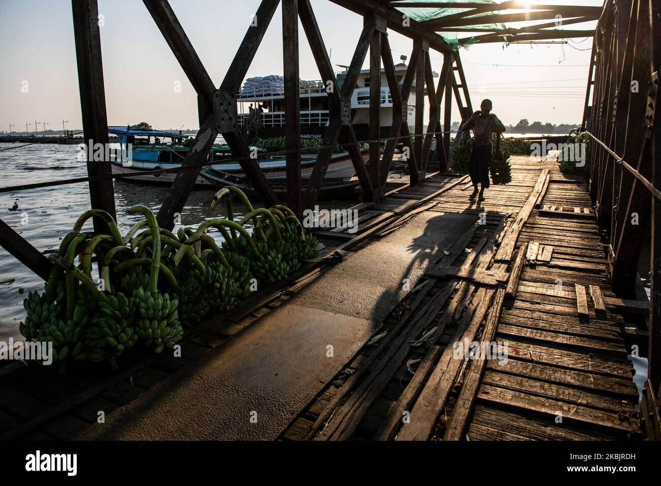 A man carries bananas unloaded from a boat at a jetty in Yangon, Myanmar on March 10, 2020. (Photo by Shwe Paw Mya Tin/NurPhoto) Stock Photo