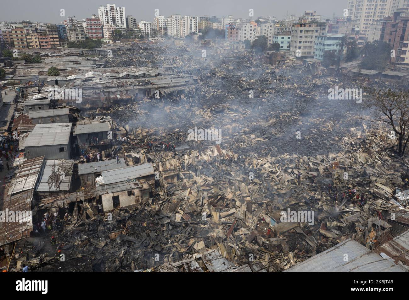 Firefighters with the help of locals work to douse a fire in a slum in Mirpur, Dhaka, Bangladesh. on March 11, 2020. More than 1,000 shanties of the slum were burnt in the fire. (Photo by Ahmed Salahuddin/NurPhoto) Stock Photo