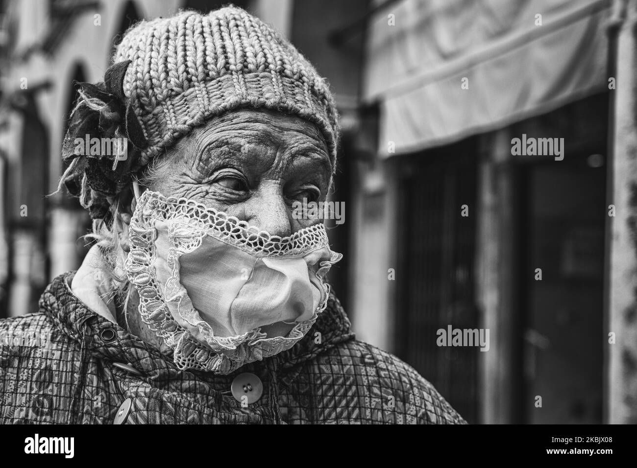 (EDITOR'S NOTE: Image was converted to black and white) An elderly lady, who went to the market in Piazza delle Erbe for shopping, wears a mask made by her at home to protect herself from the probable infection with COVID-19 (Coronavirus)., Padua, Italy, 12th March 2020 (Photo by Roberto Silvino/NurPhoto) Stock Photo