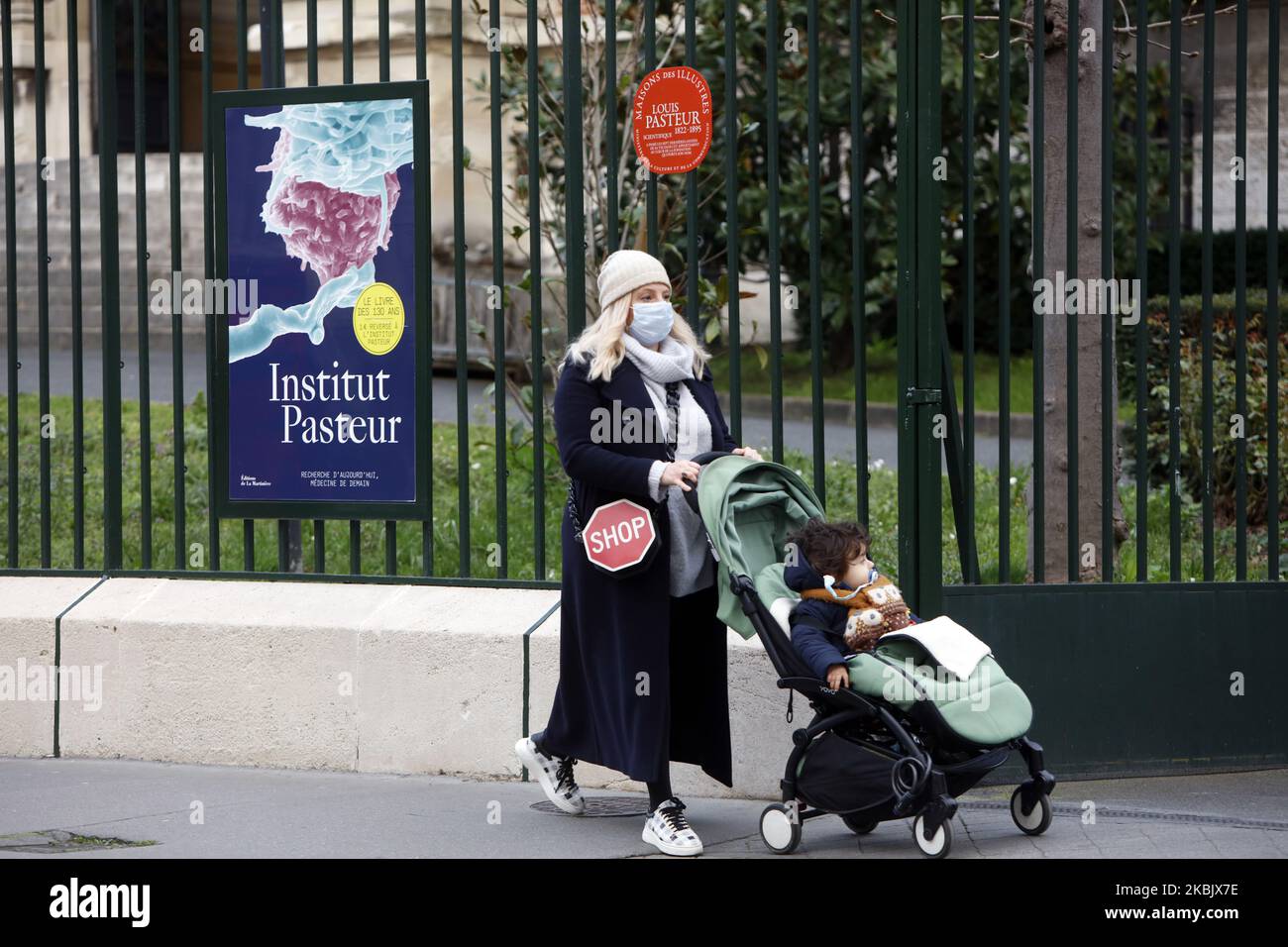 A woman with protective mask against coronavirus is walking in front of the Pasteur Institute in Paris, France, on March 12, 2020. (Photo by Mehdi Taamallah/NurPhoto) Stock Photo
