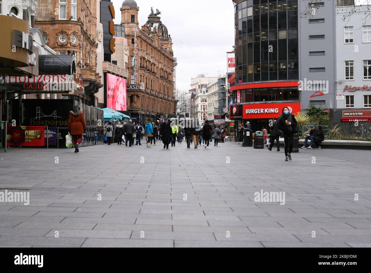 People walk through a nearly-deserted Leicester Square in London, England, on March 13, 2020. Typically busy London streets and squares were uncharacteristically subdued today as covid-19 coronavirus fears increasingly upend everyday life, keeping people away from workplaces, shops and public transport. (Photo by David Cliff/NurPhoto) Stock Photo