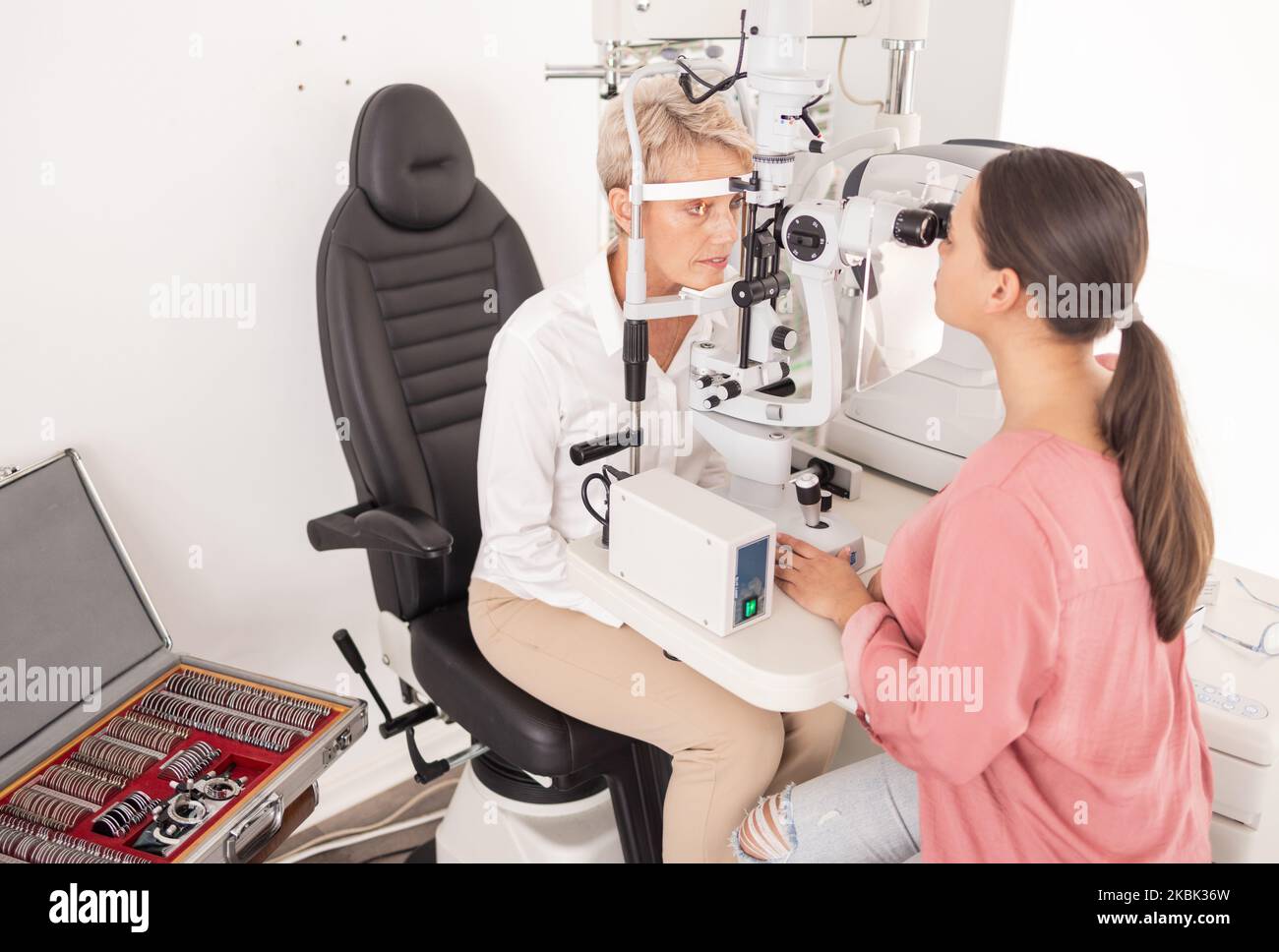 Eyes, exam and woman with ophthalmologist on a slit lamp for vision, testing and consulting at a clinic. Healthcare, medical and eye doctor with Stock Photo