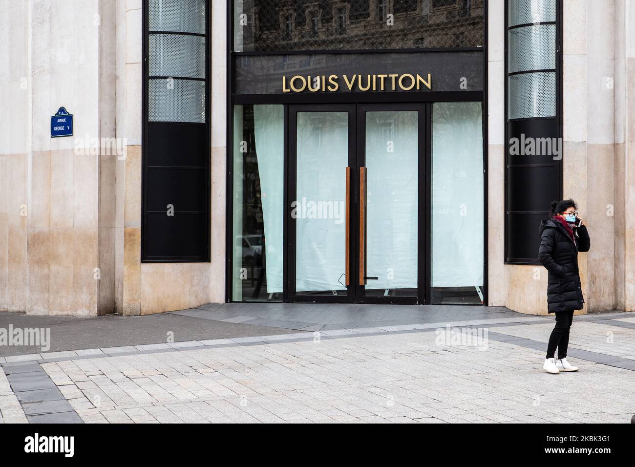 A woman wears a face mask in front the closed store Louis Vuitton on March 16, 2020 in Paris, France. France is waiting for the intervention of their president Emmanuel Macron tonight about a possible confinement, lock down, containment, of the french population against the propagation of the Coronavirus,(COVID-19). This morning in Paris the streets were almost empty, the store were closed, as the galeries Lafayette, Cartier, on the Champs Elysees avenue, and the restaurants, as Fouquet's restaurant. (Photo by Jerome Gilles/NurPhoto) Stock Photo