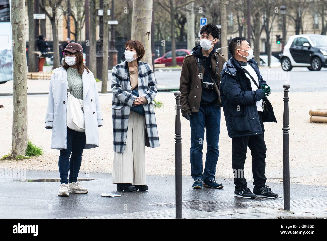 Tourists wearing a face mask as a preventive measure on March 16, 2020 in Paris, France. France is waiting for the intervention of their president Emmanuel Macron tonight about a possible confinement, lock down, containment, of the french population against the propagation of the Coronavirus,(COVID-19). This morning in Paris the streets were almost empty, the store were closed, as the galeries Lafayette, Cartier, on the Champs Elysees avenue, and the restaurants, as Fouquet's restaurant. (Photo by Jerome Gilles/NurPhoto) Stock Photo