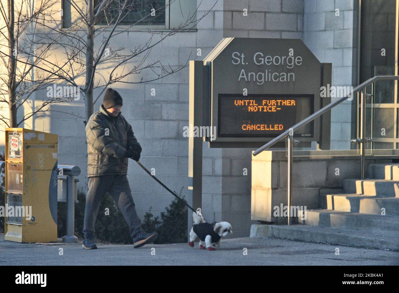Man walks his dog past one of several closed churches due to the novel coronavirus (COVID-19) in Toronto, Ontario, Canada on March 16, 2020. The province of Ontario announced yesterday that it is closing all schools, libraries, daycares, and community centres to slow the spread of COVID-19. (Photo by Creative Touch Imaging Ltd./NurPhoto) Stock Photo