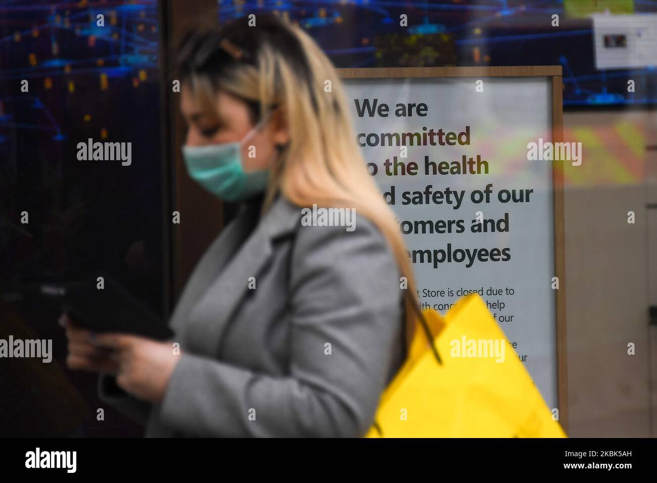 A woman wears a mask as she stands aside a closed Microsoft Store in Oxford Circus on March 17, 2020 in London, England. Boris Johnson held the first of his public daily briefings on the Coronavirus outbreak yesterday and told the public to avoid theatres and pubs and to work from home where possible. The number of people infected with COVID-19 in the UK has passed 1500 with 55 deaths. (Photo by Alberto Pezzali/NurPhoto) Stock Photo