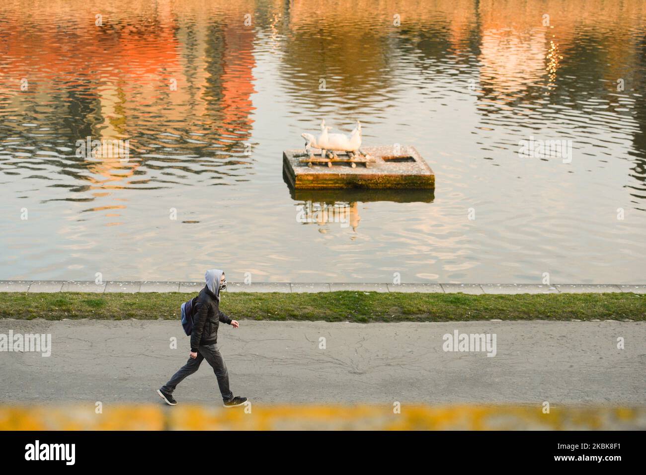 A man wearing a protective mask walks along Vistulan Boulevards in Krakow. The Ministry of Health announced another 68 new cases of coronavirus in Poland, raising the total count to 355. On Thursday, March 19, 2020, in Krakow, Poland. (Photo by Artur Widak/NurPhoto) Stock Photo