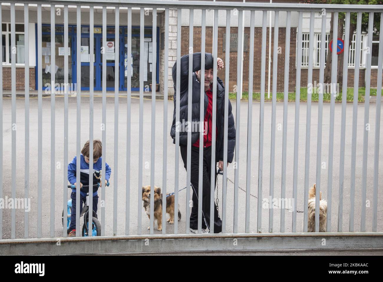 The bedel of the IES Noreña educational center walks with his dogs and his nephew inside the educational facilities closed by the health alert for the coronavirus in Norena, Spain, on March 20, 2020. Europe has become the epicenter of the COVID-19 outbreak, with one-third of globally reported cases now stemming from the region. (Photo by Alvaro Fuente/NurPhoto) Stock Photo