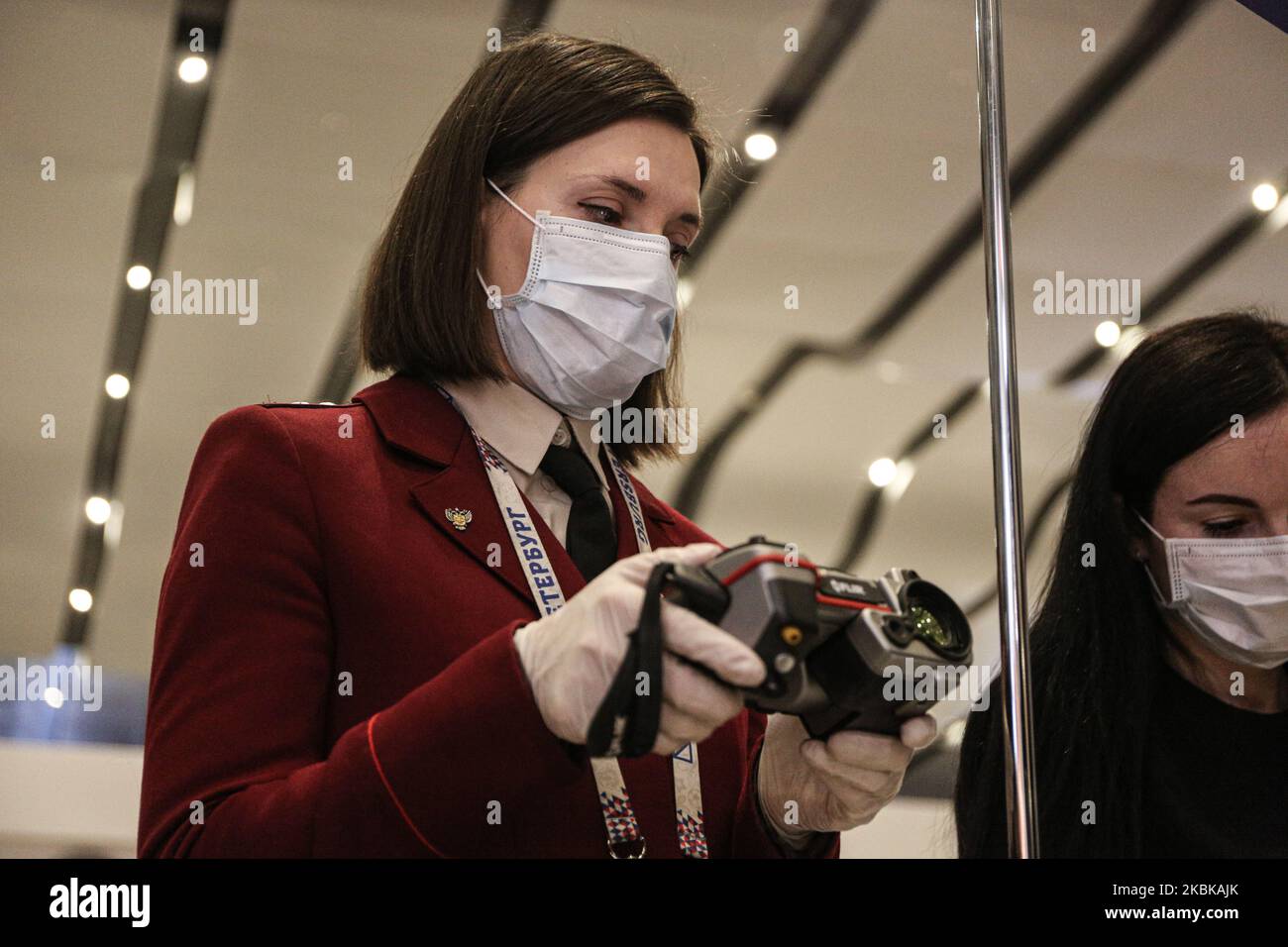 Rospotrebnadzor employees in protective masks with a thermal imager measure the temperature of arrivals at Pulkovo airport in the arrival zone in St. Petersburg. Flights to other countries have been canceled due to the coronavirus epidemic. Saint Petersburg, Russia March 20, 2020 (Photo by Valya Egorshin/NurPhoto) Stock Photo