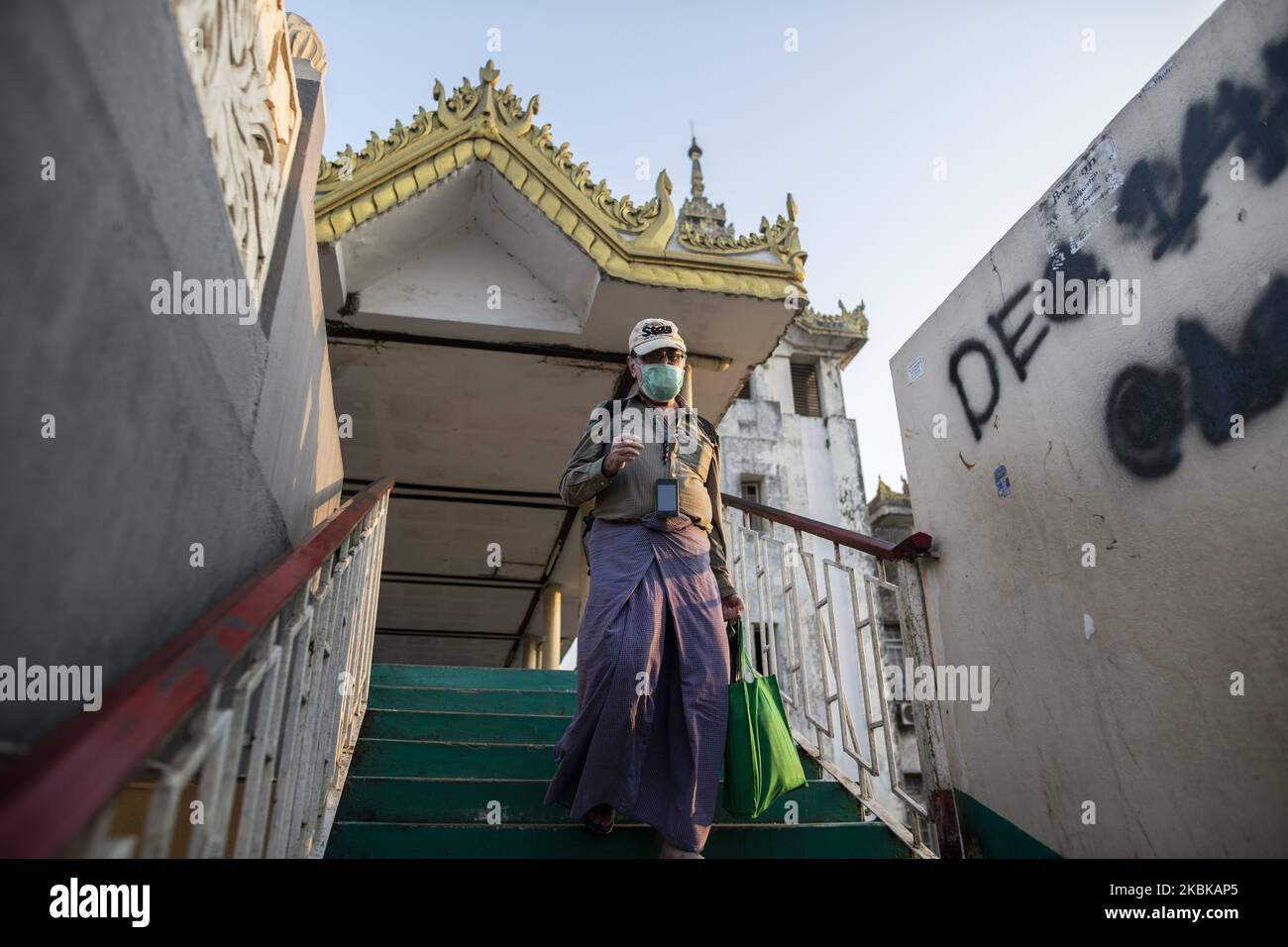 A man wearing face mask, amid concerns of the COVID-19 coronavirus, walks down the ladder in Yangon on March 21, 2020. (Photo by Shwe Paw Mya Tin/NurPhoto) Stock Photo