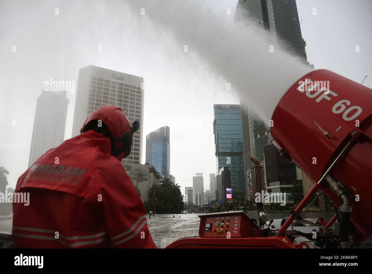 Firefighters spray disinfectant liquid in the Bundaran Hotel Indonesia area, Jakarta, on March, 22,2020. The Jakarta Provincial Government sprayed public facilities using disinfectant liquids in five areas of Jakarta to prevent the spread of the Corona virus or COVID-19. (Photo by Dasril Roszandi/NurPhoto) Stock Photo