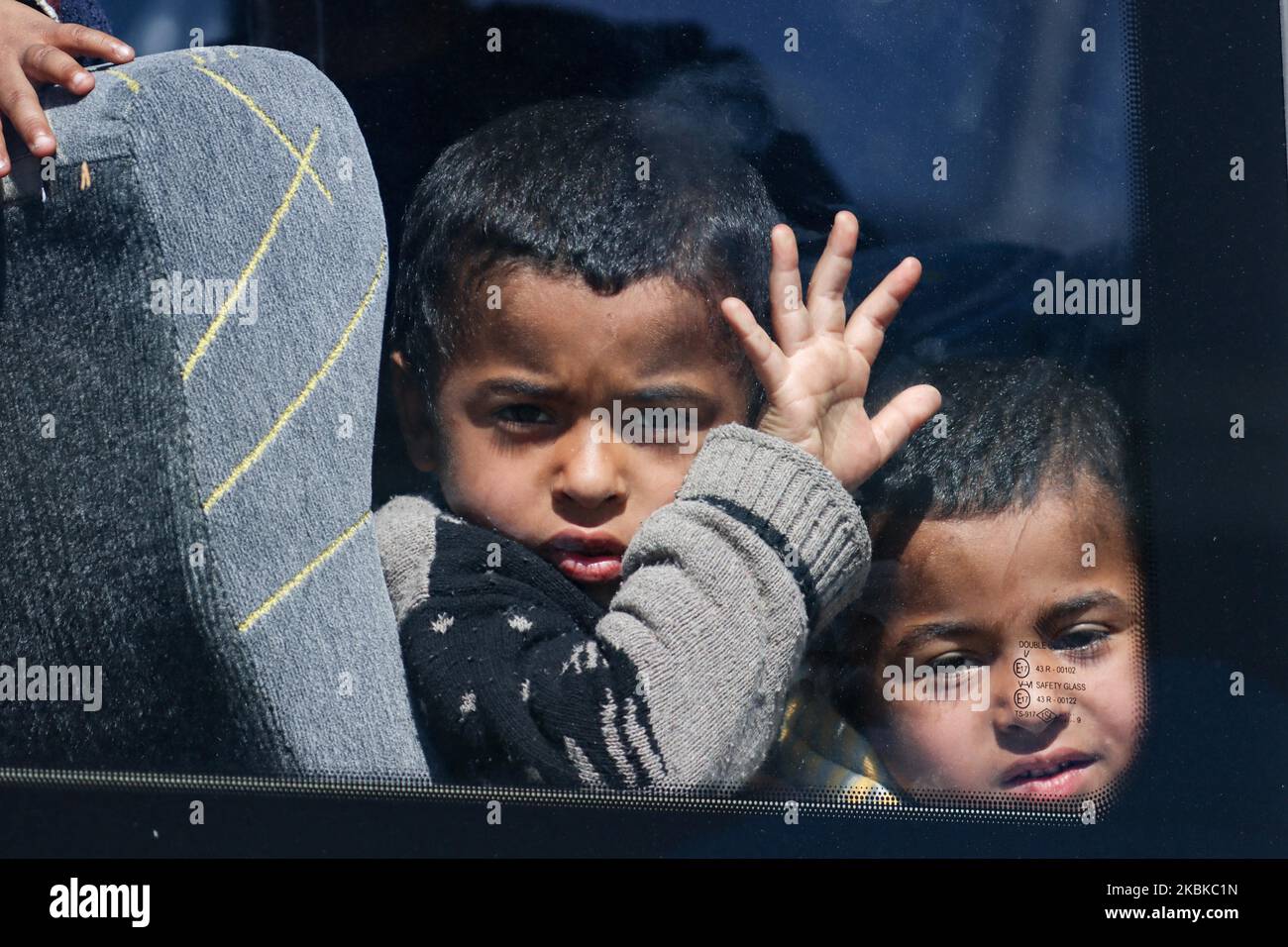 Children wait in the bus before taking them to the new camp. New refugee and migrant camp facility in Greece at Kleidi area near Promahonas village in Serres region, at Greek - Bulgarian borders, is receiving the first wave of people, asylum seekers who entered Greece after 1st of March 2020 where the country stopped accepting asylum applications. Newcomers are from the islands Lesvos, Samos and Chios and have been transferred by ferry to Kavala and then to Kleidi by bus in order to record them, photograph, temporarily host and then deport to them back to their country of origin like Afghanist Stock Photo