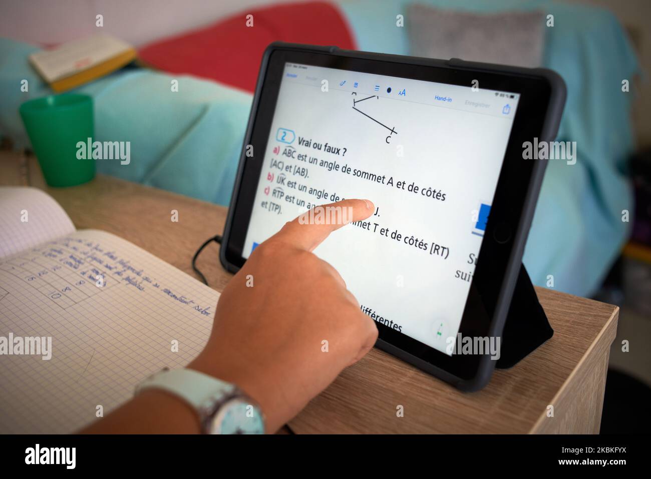 A pupil does maths on a tablet. For the 7th day, French people are on lockdown. Schools, highschools, universities are closed since March 13th. French Education minister Jean-Michel Blanquertold teachers to give online courses. Parents and children must interact to work together and for children to do their homeworks and receive online courses. They use videoconference and e-learning. Toulouse. France. March 24th 2020. (Photo by Alain Pitton/NurPhoto) Stock Photo