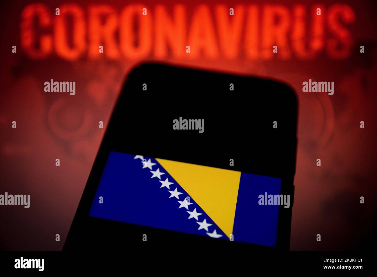 In this photo illustration a Bosnia and Herzegovina flag is displayed on a smartphone with background a Coronavirus picture on March 25, 2020 in Athens, Greece. (Photo by Nikolas Kokovlis/NurPhoto) Stock Photo