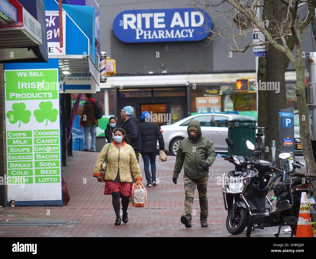 People with facemasks are seen outside a drug store in Queens, New York