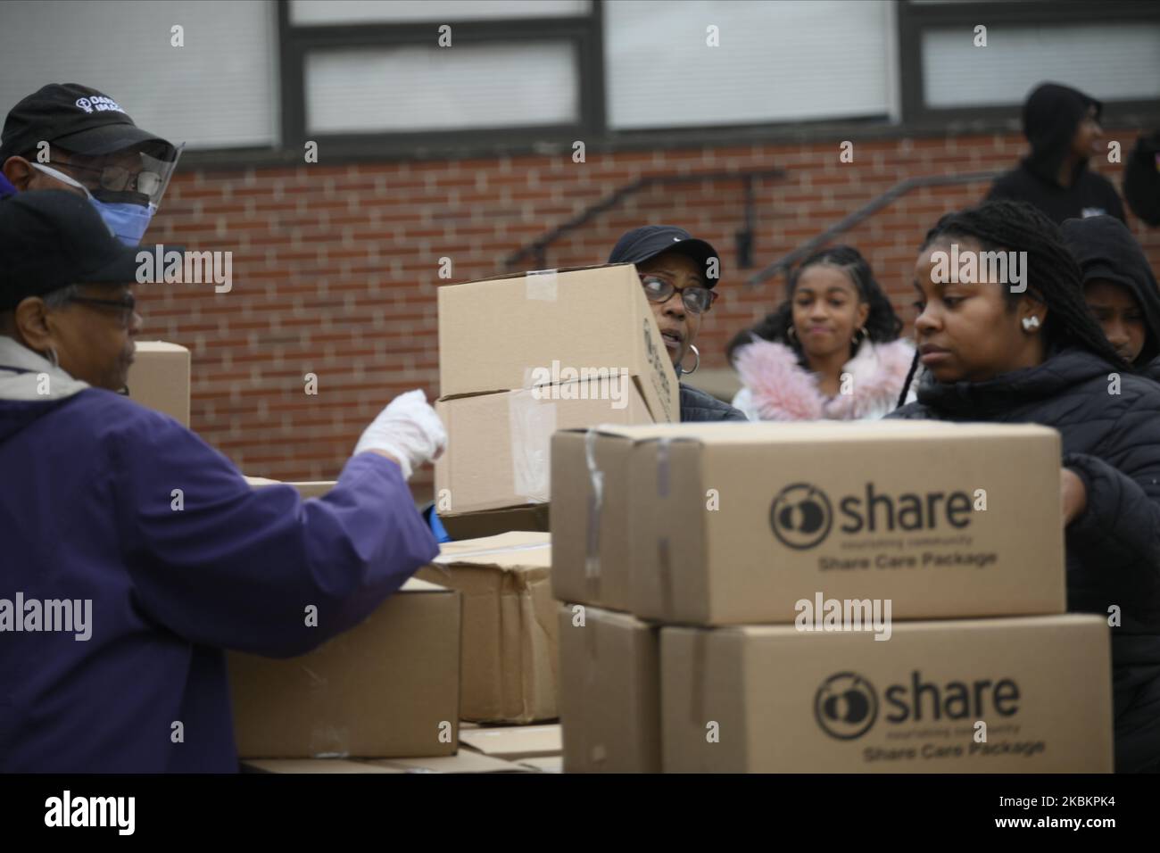 Community members receive free food package at a distribution location in Northwest section of