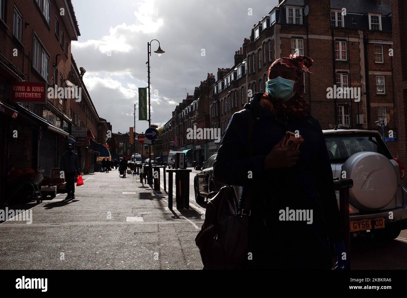A woman wearing a mask walks along East Street in the borough of Southwark, which has among the highest number of covid-19 coronavirus cases anywhere in the UK, in London, England, on March 30, 2020. Official figures report that Southwark currently has 368 cases of covid-19, the highest in London and fifth highest in the UK as a whole, behind Sheffield (428), Glasgow (449), Hampshire (498) and Birmingham (578). The neighbouring London borough of Lambeth is similarly hard-hit, with 366 cases, sixth-highest in the UK. Britain meanwhile began its second week of lockdown today, with the measures s Stock Photo