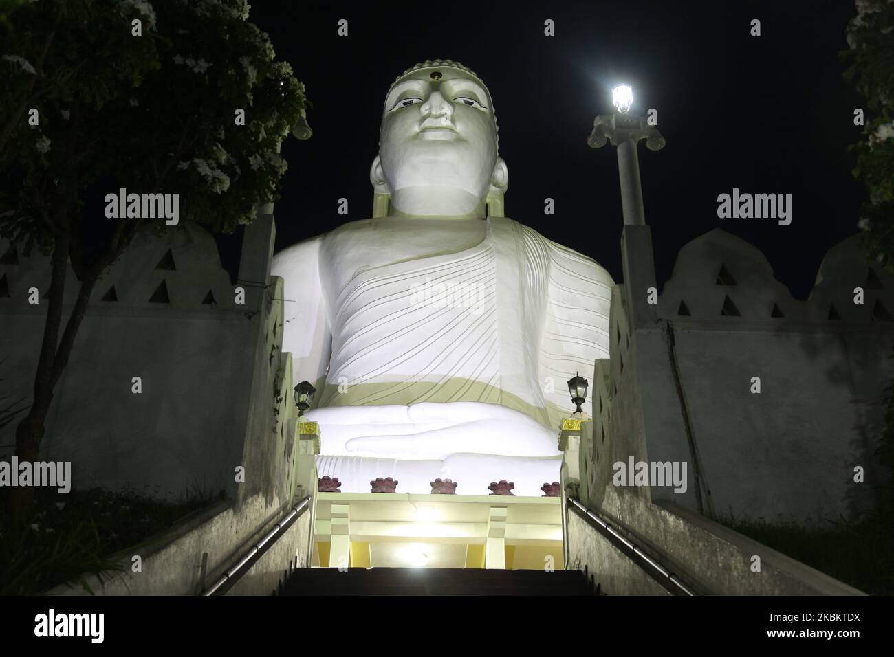 The giant Bahiravokanda Vihara Buddha Statue illuminated at night at the Sri Maha Bodhi Viharaya Buddhist temple in Kandy, Sri Lanka. The temple located in Bahirawakanda and is known for its giant Buddha statue. The statue of Buddha is depicted in the position of the Dhyana Mudra, the posture of meditation associated with his first Enlightenment, and can be seen from almost everywhere in Kandy. The statue is 26.83 m (88.0 ft) high and is one of the tallest Buddha statues in Sri Lanka. (Photo by Creative Touch Imaging Ltd./NurPhoto) Stock Photo