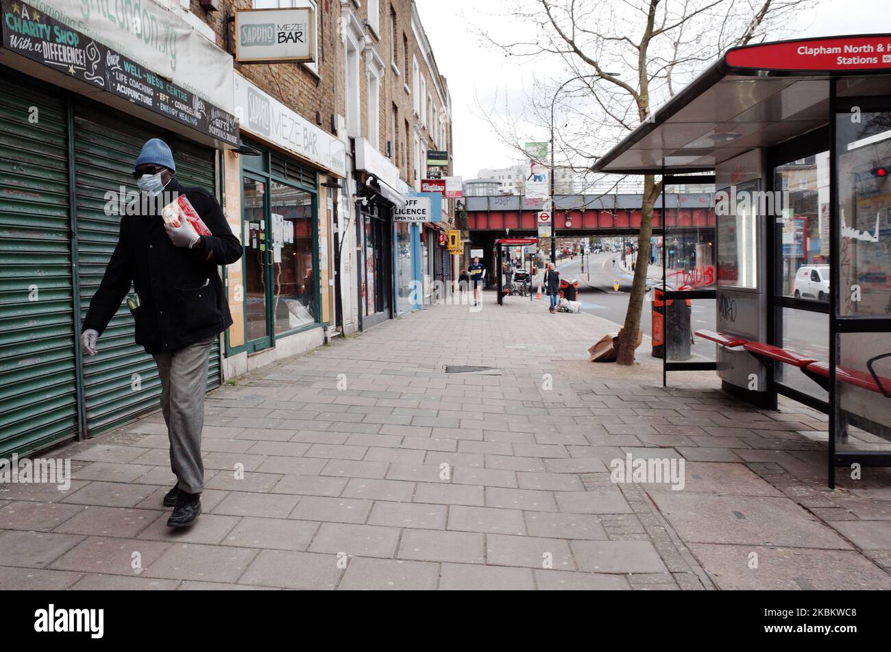 A man wearing a mask carries shopping along Clapham High Street in the borough of Lambeth in London, England, on April 1, 2020. Official figures report that Lambeth currently has 418 recorded cases of the covid-19 coronavirus, higher than any other local authority district in London and fourth among local authorities in England as a whole (behind Sheffield, Hampshire and Birmingham). The borough was previously trailing the neighbouring south London district of Southwark, which remains similarly hard-hit, currently with 415 cases. (Photo by David Cliff/NurPhoto) Stock Photo