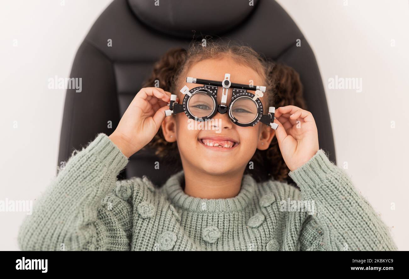 Vision, eye exam and girl with trial lens for prescription spectacles at optometry shop. Eyewear, eyesight test and happy child trying new optical Stock Photo