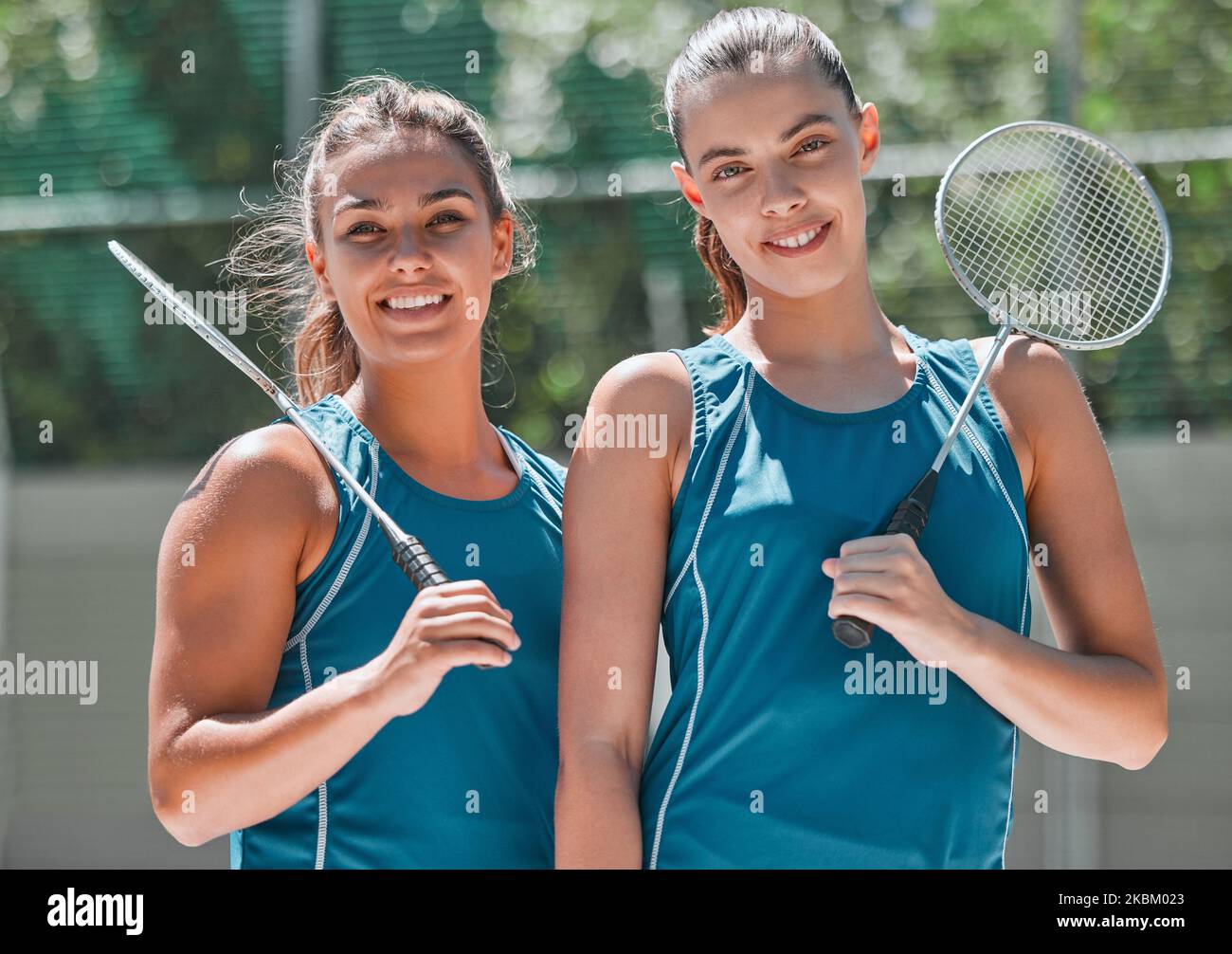 Badminton, women and sport team ready for game and exercise on an outdoor court. Portrait of a teamwork duo athlete group with a happy smile looking Stock Photo