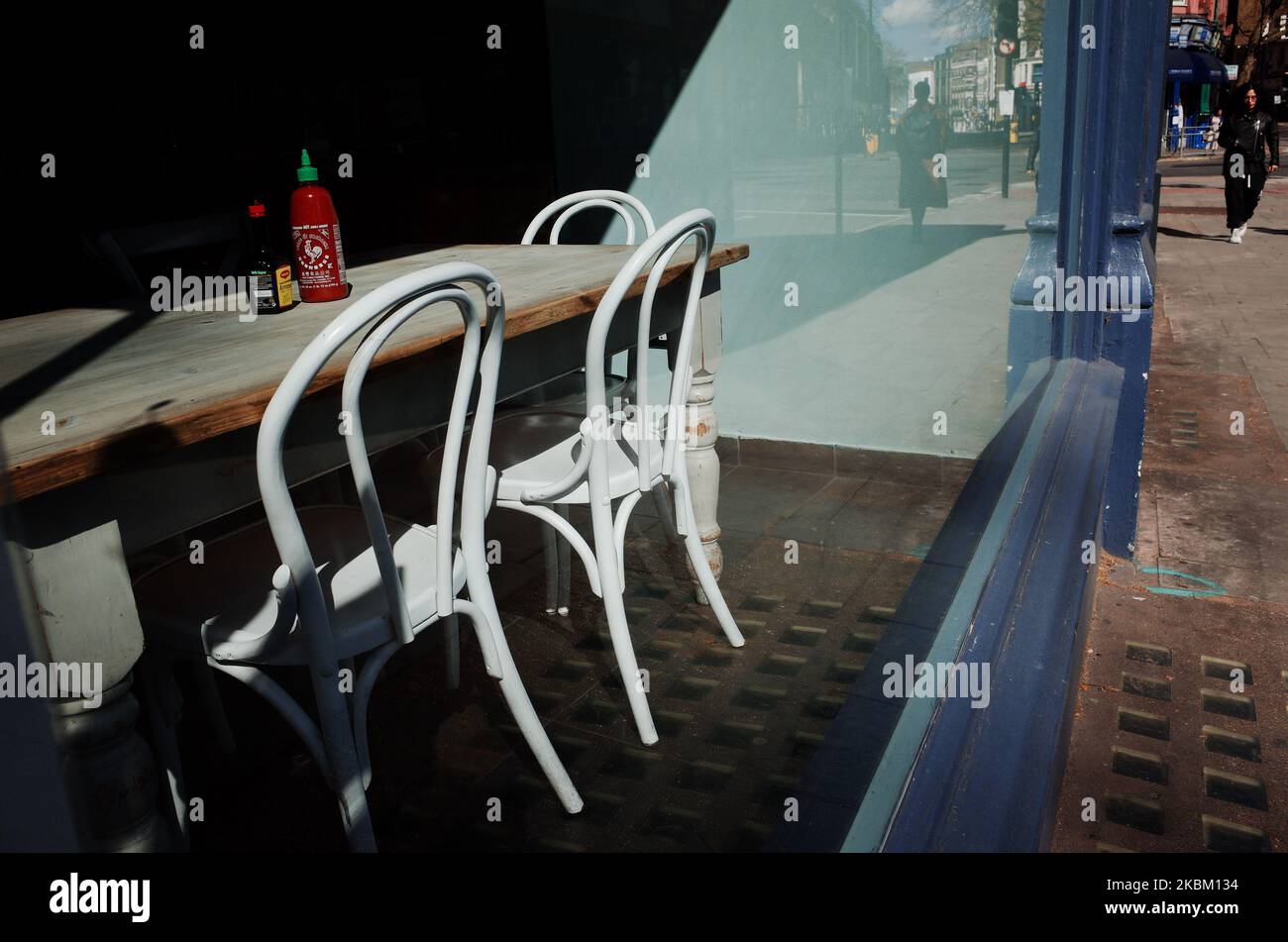 An empty table stands in the window of a closed cafe on Theobalds Road in the Bloomsbury district of London, England, on April 4, 2020. Across the UK a total of 41,903 cases of the covid-19 coronavirus have so far been confirmed, with 4,313 people having died. The country meanwhile is now nearly a fortnight into its 'lockdown', which is set to be reviewed after an initial three-week period, although an extension is widely expected. Britain's Secretary of State for Health and Social Care Matt Hancock insisted yesterday that the government's continued insistence on people staying at home to avoi Stock Photo