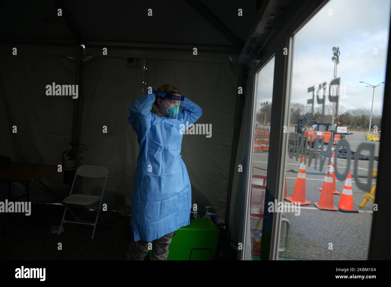 Alyssa Volkmer, age 25, puts on her personal protective equipment at the drivethrough COVID19