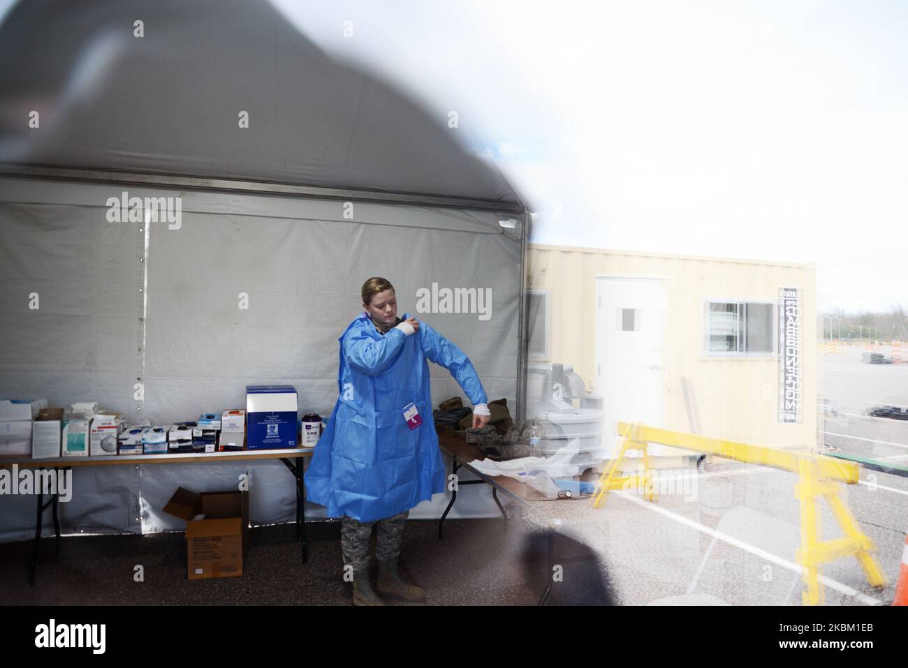 Alyssa Volkmer, age 25, puts on her personal protective equipment at the drivethrough COVID19
