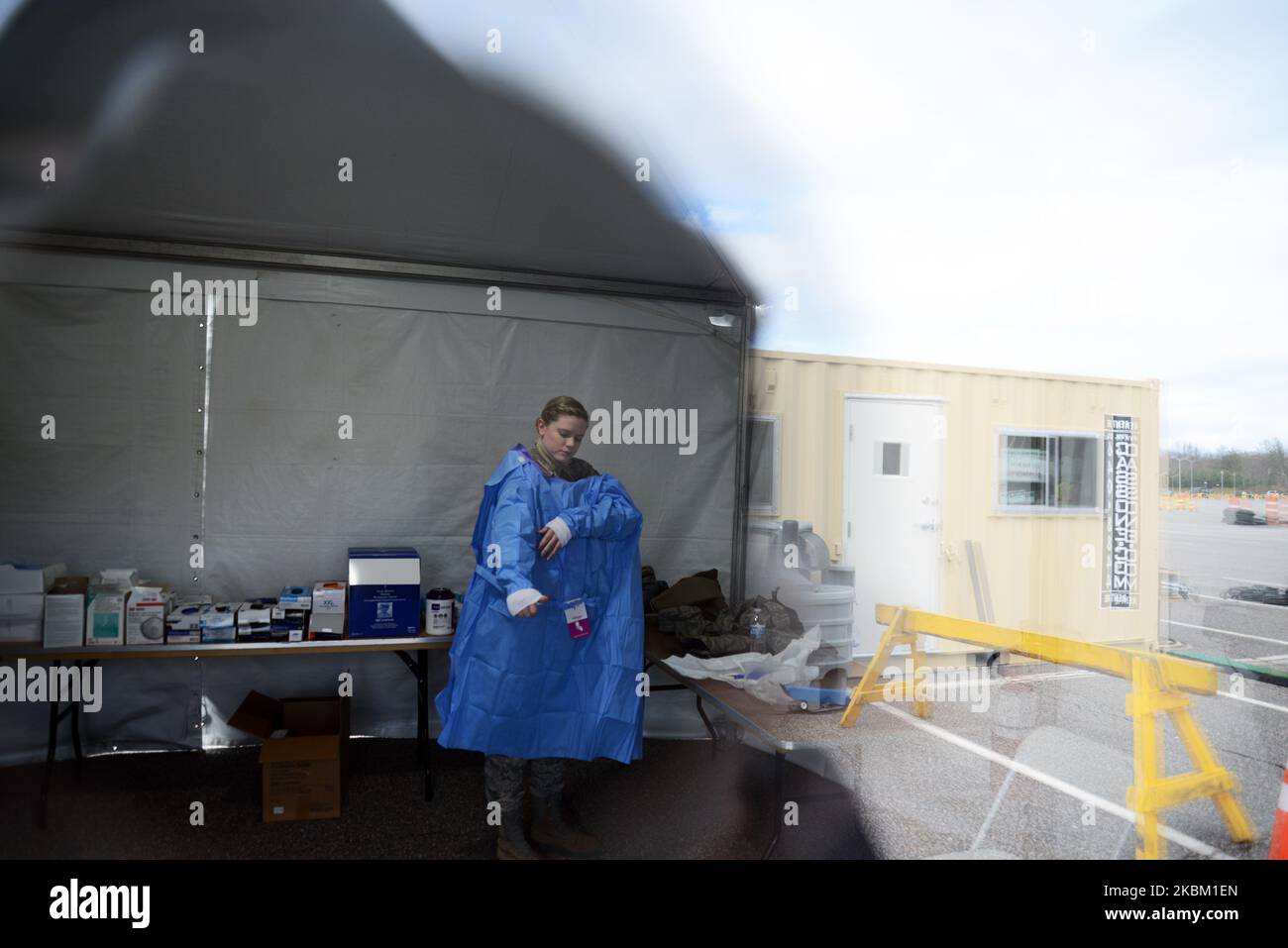 Alyssa Volkmer, age 25, puts on her personal protective equipment at the drivethrough COVID19