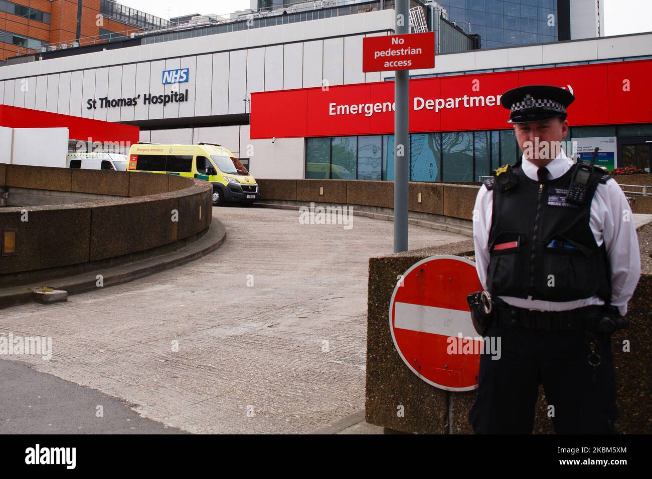 A police officer stands guard outside St Thomas' Hospital, where British Prime Minister Boris Johnson remains in intensive care with the covid-19 coronavirus, in London, England, on April 8, 2020. Johnson, 55, was admitted to the hospital on Sunday evening with what were described as 'persistent symptoms' of the novel coronavirus. He was moved to intensive care on Monday night after his condition was said to have 'worsened'. Chancellor of the Exchequer Rishi Sunak informed the country today, however, that the prime minister was now improving, sitting up and 'engaging positively' with the medic Stock Photo