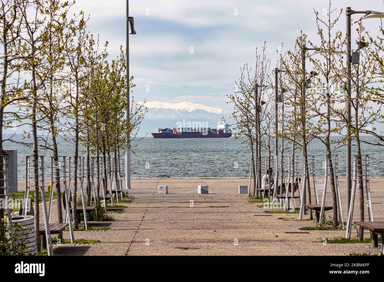 A freight vessel as seen from the seafront of Thessaloniki city anchored at Thermaikos Gulf, Aegean Sea in Greece on April 7, 2020. The cargo ship carries containers shipment and is under the name Ef Emira, with IMO registration number 9357810, sailing under the flag of Marshall Islands. The ship waits to unload its merchandise at the Port of Thessaloniki, the second-largest container port in Greece but there is a delay in the port due to Covid-19 Coronavirus Pandemic. Snow covered Mount Olympus is visible in the background. (Photo by Nicolas Economou/NurPhoto) Stock Photo