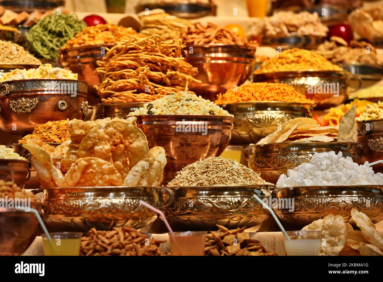 Mountains of sweets and vegetarian snacks are displayed in front of the