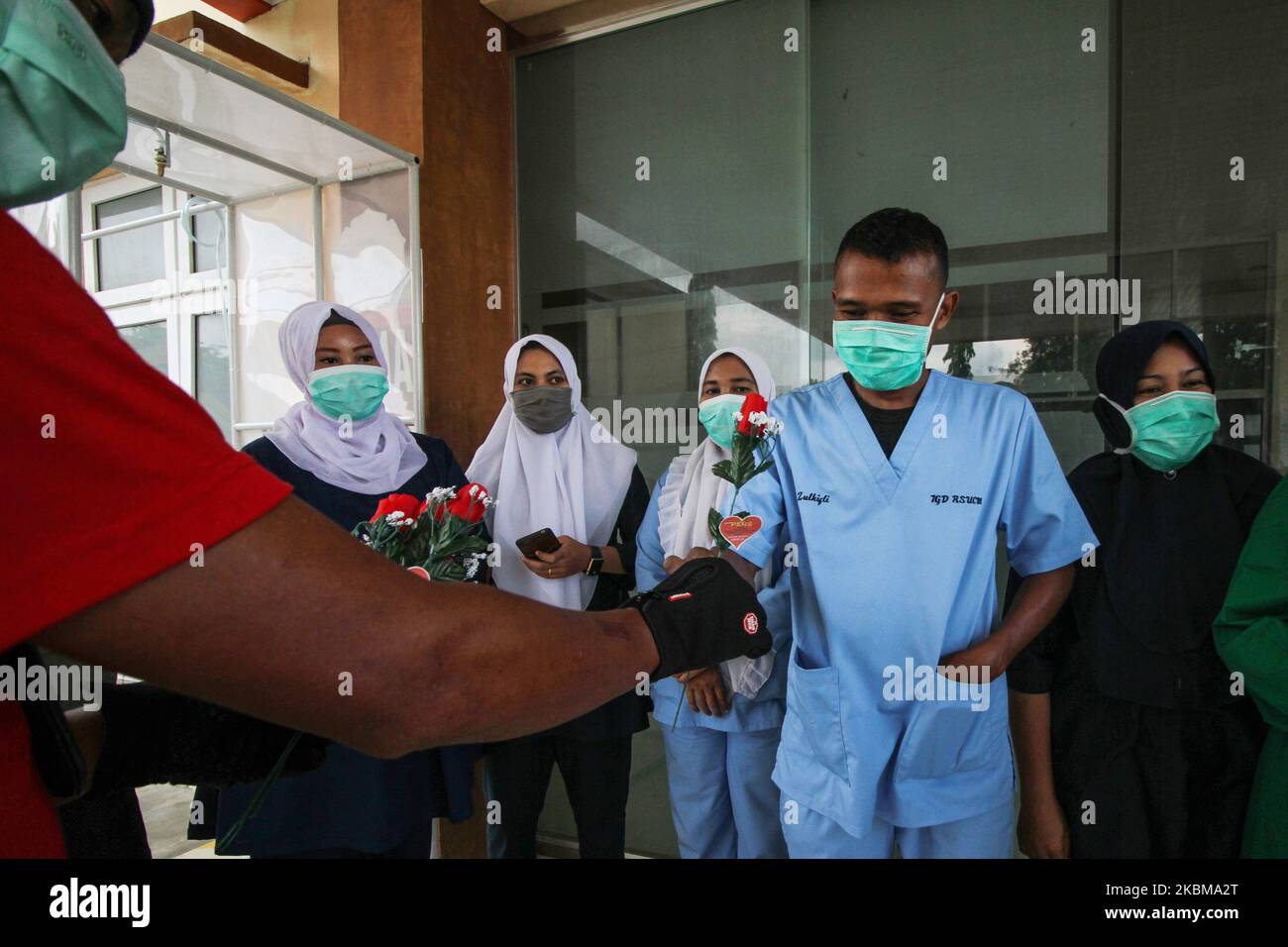 A journalist is seen distributing roses to medics at a hospital, as a form of support amid concerns over the spread of the COVID-19 coronavirus, in Lhokseumawe, on April 11, 2020, Aceh, Indonesia. According to the latest report, on April 11, Indonesia confirmed 3,842 COVID-19 cases with 327 deaths and 286 were cured. (Photo by Fachrul Reza/NurPhoto) Stock Photo