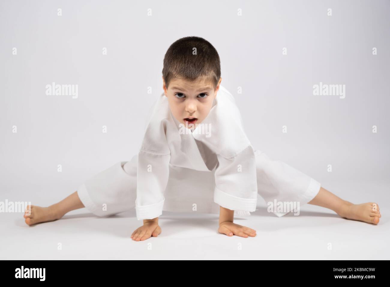 A strong 5yearold karate boy karate in a kimono on a white background