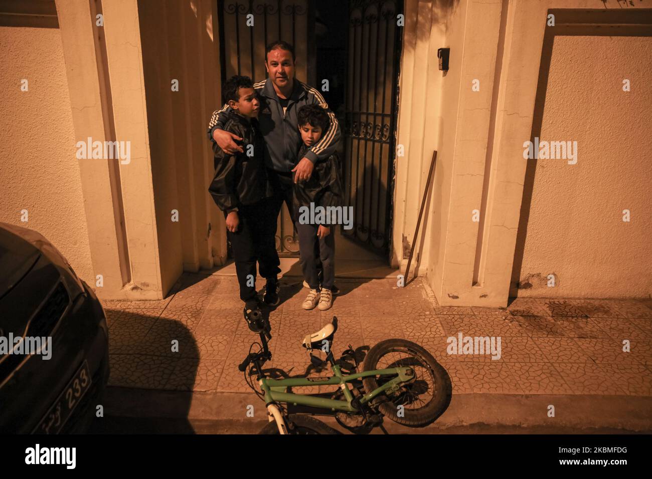 A father with his teenage sons, pose for photos outside their house, after they trained in Karate, at night and during the curfew imposed by the president of Tunisia, Kais Saied, in Ariana governorate, Northern Tunisia, as they try to chase away the vacuity, the stress and to stay in shape during the general lockdown imposed by the Tunisian authorities in bid to slow down the spread of the novel coronavirus outbreak that causes the Covid-19 disease in Tunisia, on April 06, 2020. (Photo by Chedly Ben Ibrahim/NurPhoto) Stock Photo