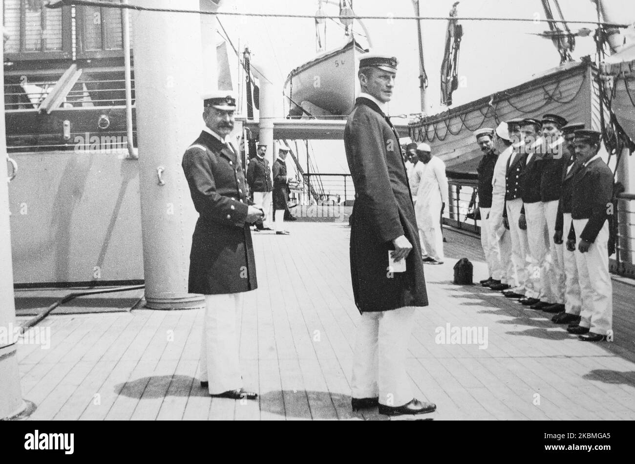 The Captain of a ship, carrying British troops and supplied for The Boer War, inspects his crew members on deck. Stock Photo