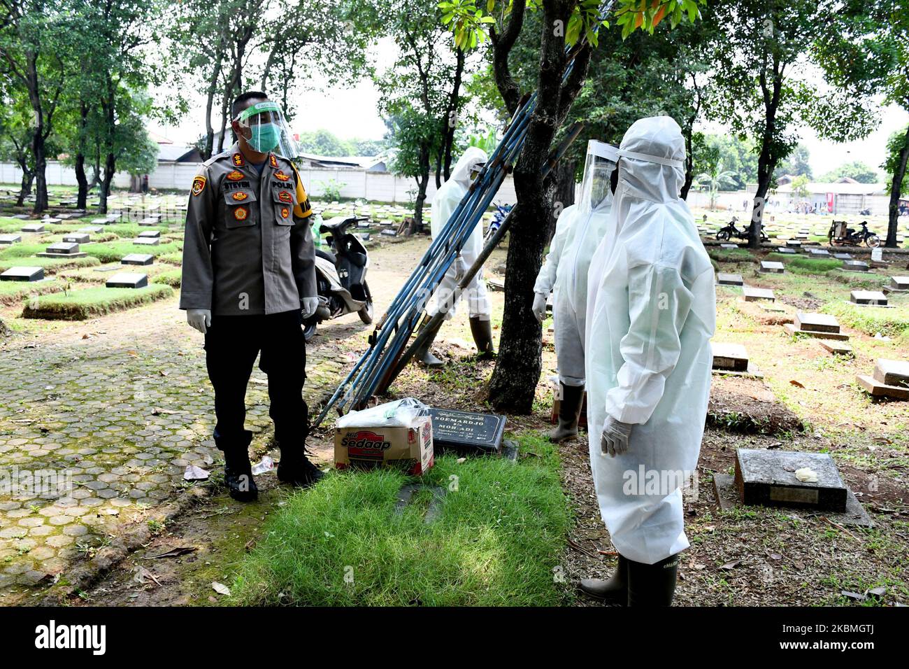 Indonesian funeral service workers wear face shields at Pondok Rangon gravetard in Jakarta