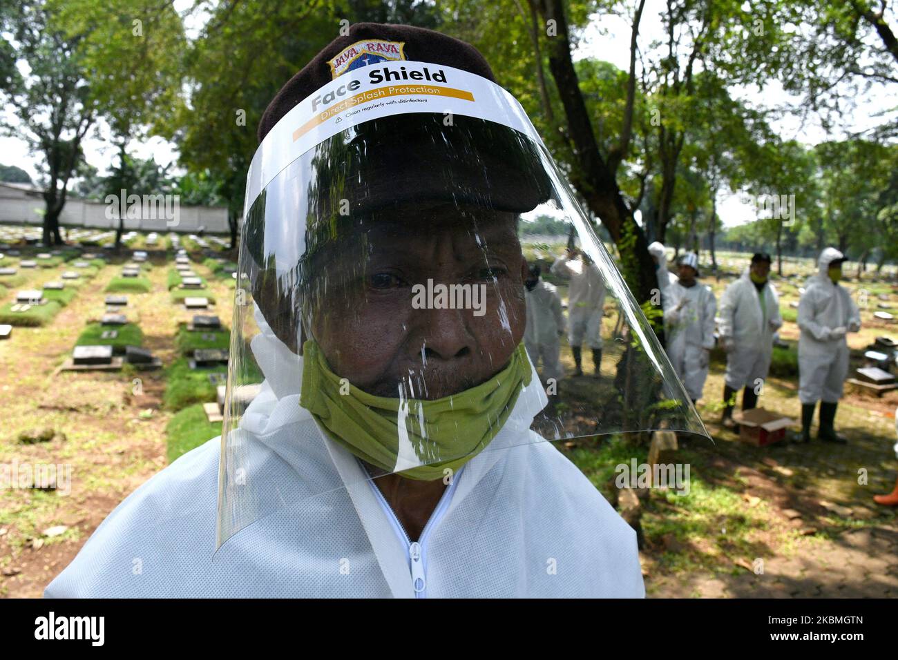 Indonesian funeral service workers wear face shields at Pondok Rangon gravetard in Jakarta