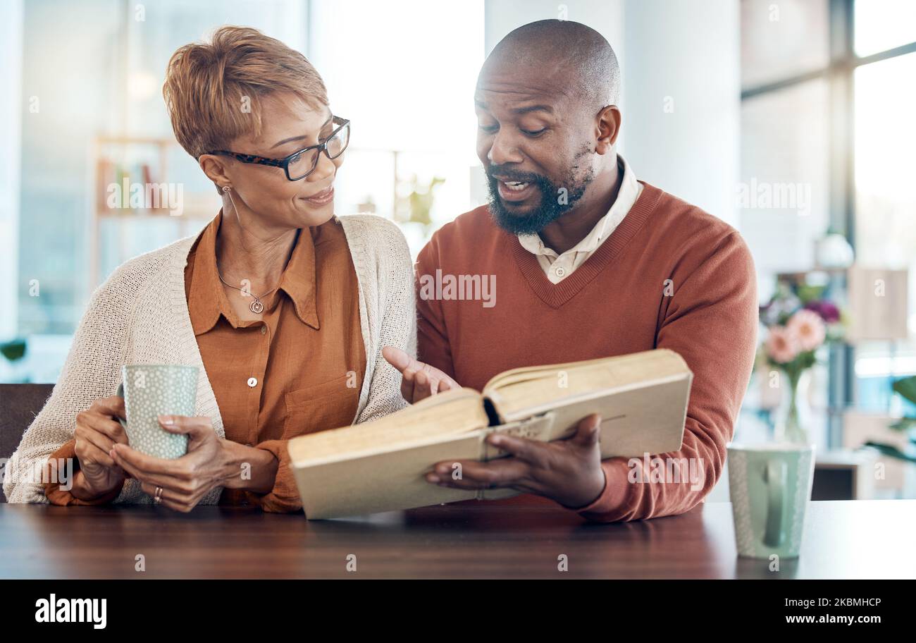 Christian, prayer or black couple reading bible book for faith, worship or bible study in kitchen or living room. Coffee, happy or man and woman for Stock Photo