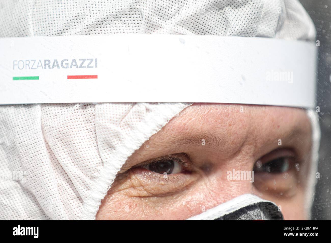 A detail on the writing 'Forza Ragazzi' of the protective mask - Healthcare professional performs drive through swab to detect covid-19 during COVID-19 pandemic in Italy on April 18, 2020 in Carpi, Italy. (Photo by Emmanuele Ciancaglini/NurPhoto) Stock Photo