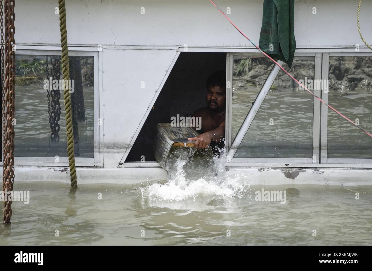 Worker bailing water from a boat in the Brahmaputra river, after heavy rainfall, during the nationwide lockdown to curb the spread of coronavirus, in Guwahati, Assam, India on Sunday, April 19, 2020. (Photo by David Talukdar/NurPhoto) Stock Photo