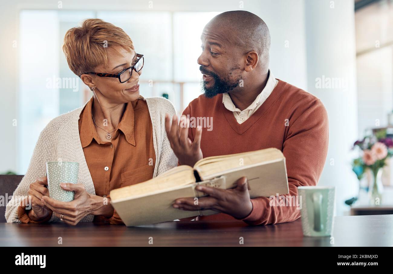 Couple reading bible, home faith and talking about religion with coffee for learning, study and education. Black man, holy book in hand and spiritual Stock Photo