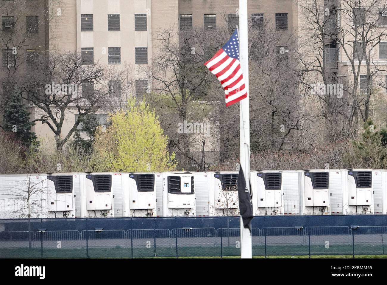 A view of American flag on halfstaff in front of rows of refrigerated